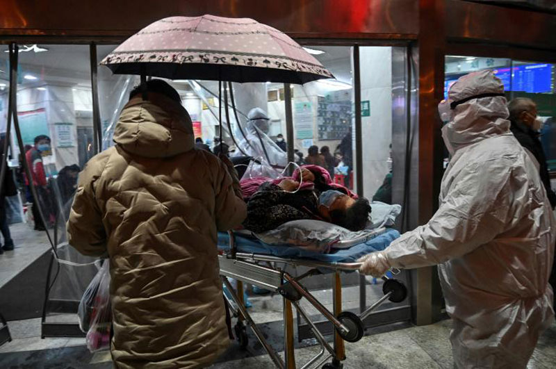 Des soignants en combinaison intégrale de protection prend en charge un patient contaminé par le coroanavirus à l'hôpital de Wuhan, le 25 janvier 2020 en Chine (AFP/Archives - Hector RETAMAL)