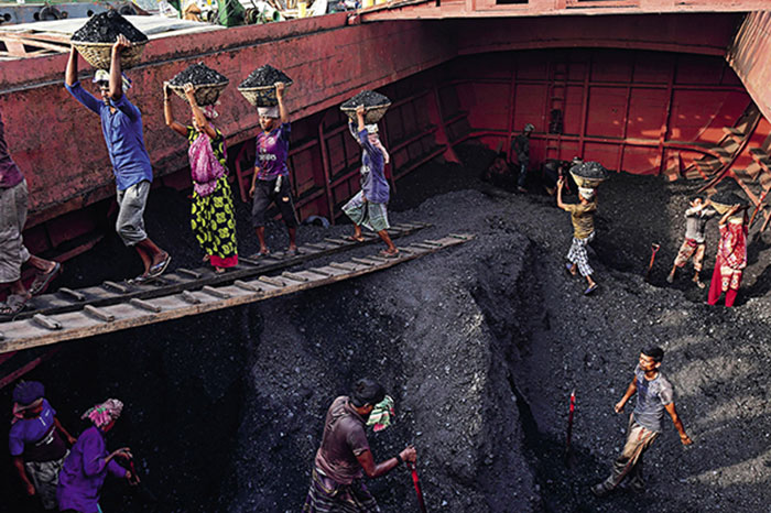 Le charbon est déchargé d’un cargo à Gabtoli, dans la banlieue de Dhaka, le 6-11-2019 