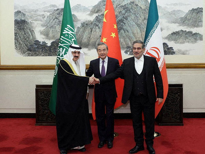 Le responsable saoudien de la sécurité nationale Musaid Al Aiban rencontre son homologue iranien Ali Shamkani, sous l'égide de Wang Yi, chef de la diplomatie chinoise, le 10 mars 2023 à Pékin. (Chinese Foreign Ministry / Anadolu Agency / AFP) 