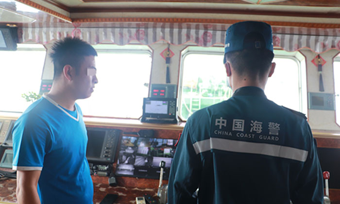 Des officiers de la Garde côtière chinoise montent à bord de bateaux de pêche pour inspecter les filets et le matériel de pêche. Photo : CCG